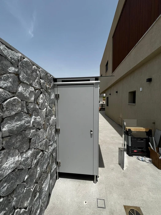 תא שירותים מטרספה בבית פרטי בחצר סמוך לבריכת שחיה